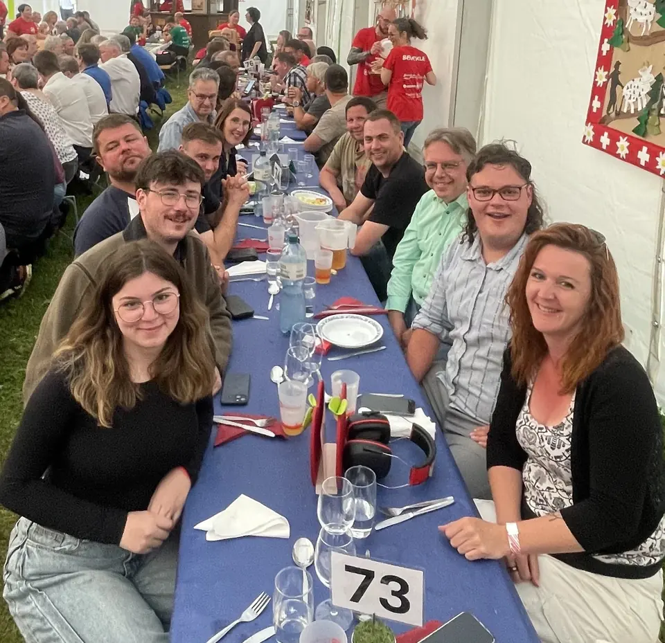 Les membres de l'équipe du stand de tir 300m de Villeneuve réunis autour d'une table pendant un repas convivial